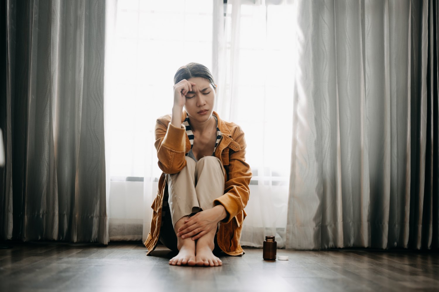 Asian woman sit Depression Dark haired pensive glance Standing by window and anxiety Copy space.
