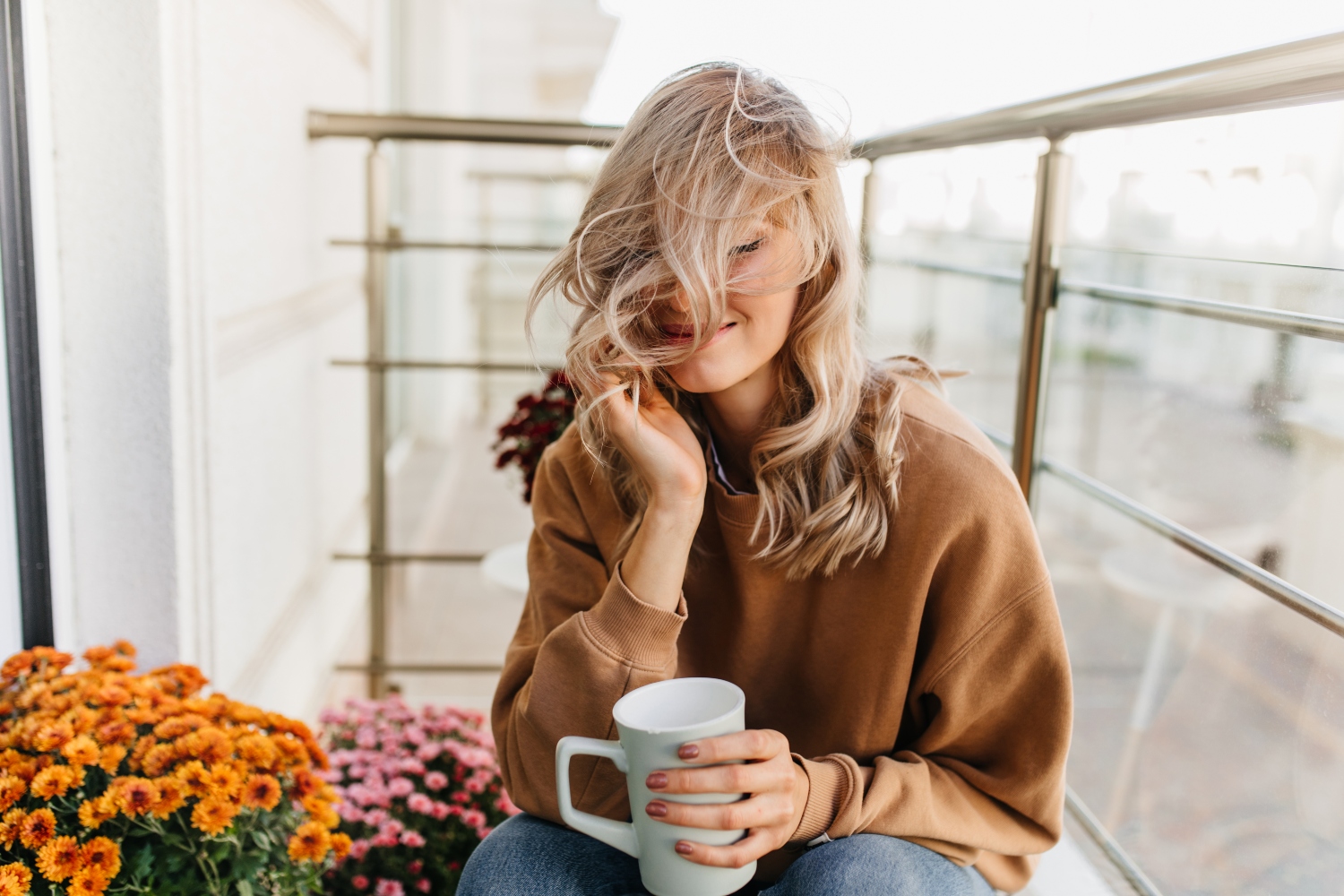 woman sitting at balcony with cup of tea, concept of self-compassion, relaxation, happiness