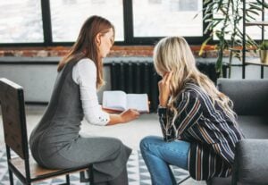 women discussing joint project, coaching or psychotherapy in an office