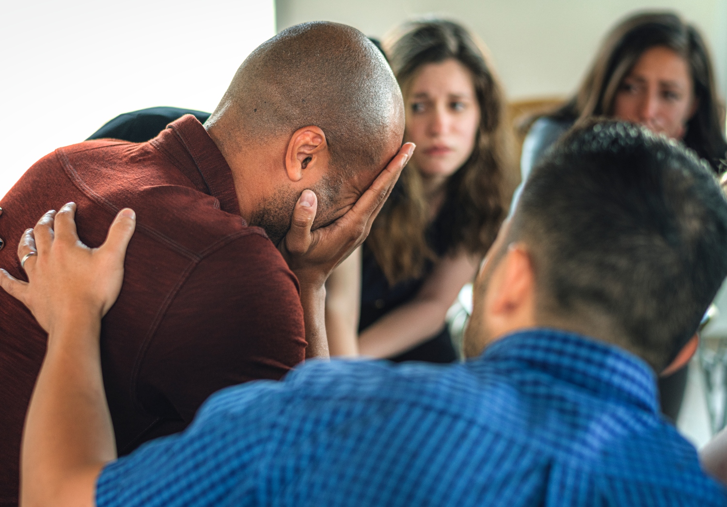 people listening to a man during group therapy session