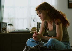 woman looking tired, depressed while sitting alone in a room