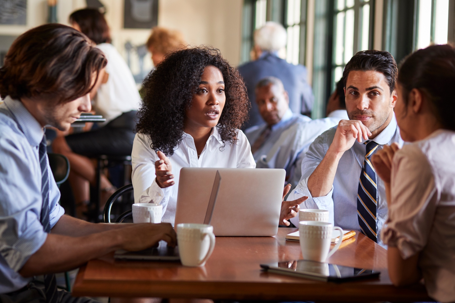 Business Team Having Informal Meeting Around Table In Coffee Shop