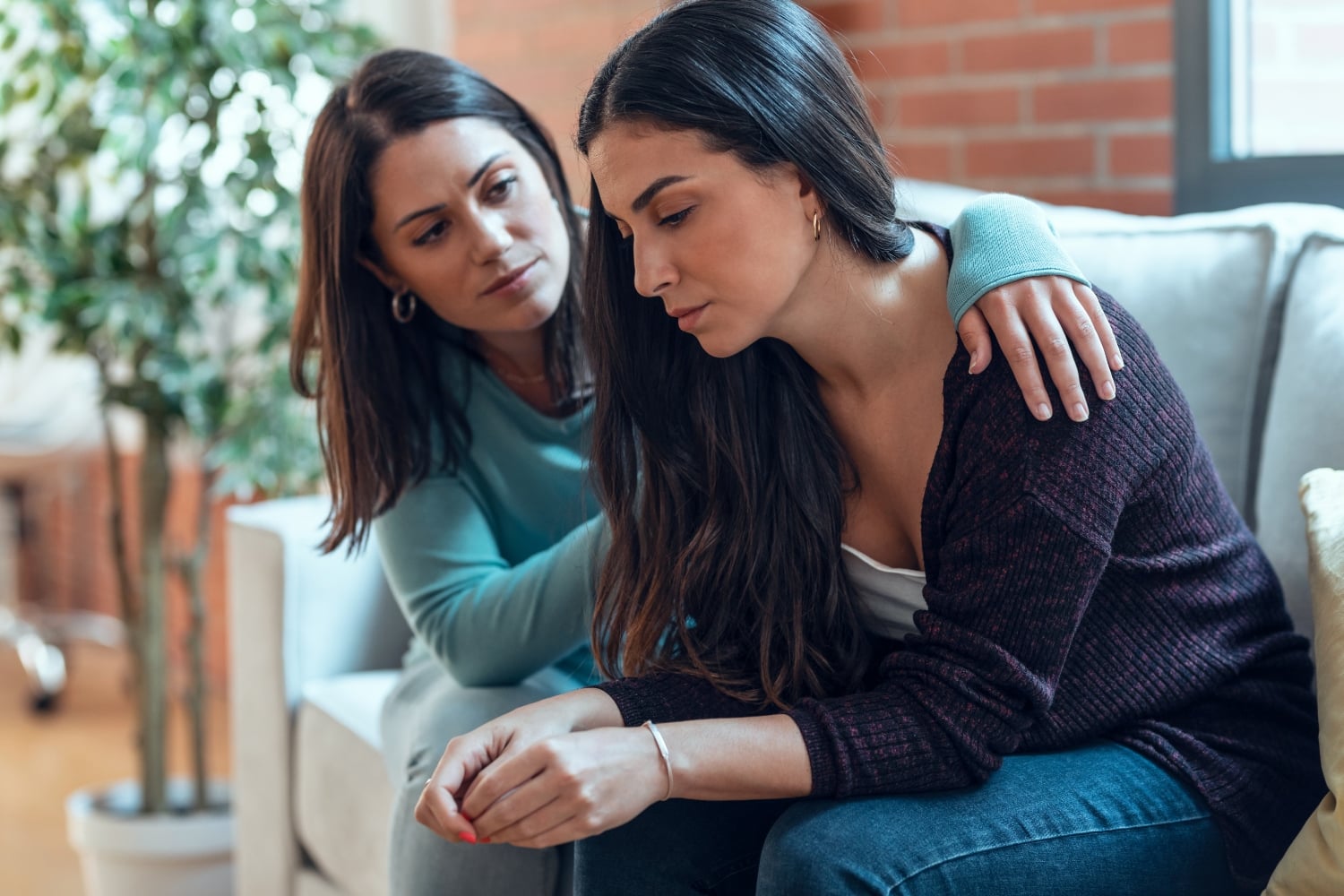 woman comforting a friend while sitting together, concept of struggles with anxiety, depression