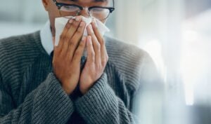 Adult Covering Nose With Tissue Indoors