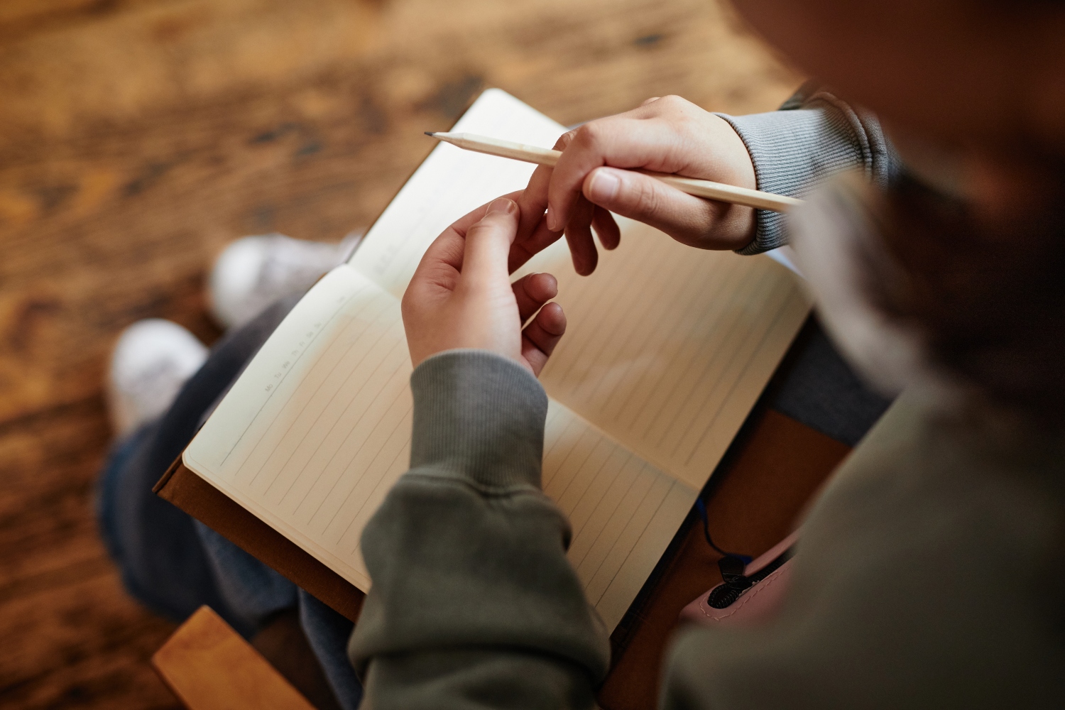 focused shot of a woman's hand while planning to write on a journal