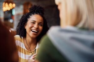 woman laughing while being with her friends in a cafe